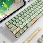 A charming Le Petit Prince PBT MOA keycap from a unique angle, highlighting its whimsical storybook design with cute prairie and nature-themed elements.
