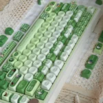 "Detailed shot of the whimsical Matcha Totoro PBT keycap set, revealing charming Totoro characters amidst calming matcha green and soft forest hues."