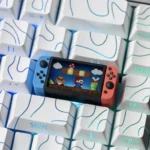 Close-up gallery views of a playful, translucent Nintendo Switch Series Super Mario keycap, showcasing its intricate miniature console design from various angles.