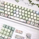 Meadow Ode Luminous Side-Lit PBT keycap set, displayed from various angles, highlighting its tranquil nature-inspired designs and soft luminous glow.