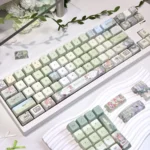 Meadow Ode 134-key MDA PBT keycap set, showcasing its luminous, nature-inspired, side-lit design. Refined textures and soft glow evoke tranquil.