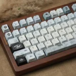 Detailed view of handcrafted Plum Blossom Frost PBT keycaps. Serene plum blossoms with frosty accents on a dark, traditional Chinese design.