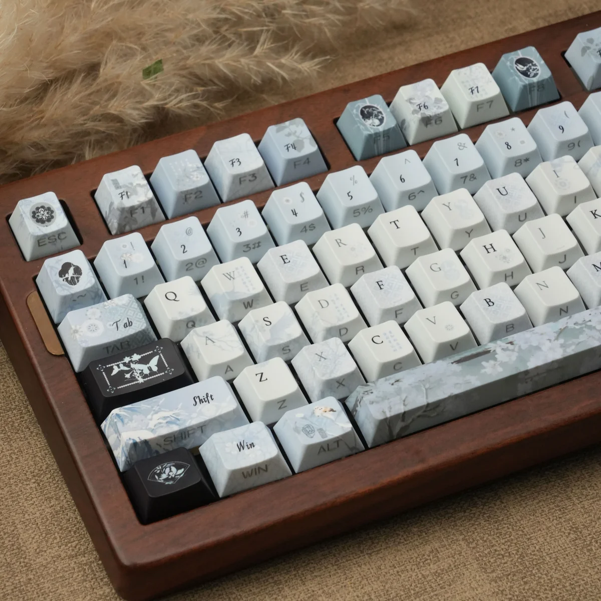 Detailed view of handcrafted Plum Blossom Frost PBT keycaps. Serene plum blossoms with frosty accents on a dark, traditional Chinese design.