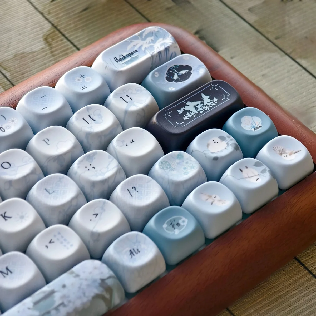 Close-up of handcrafted Plum Blossom Frost Keycaps, showcasing the intricate, serene plum blossom artistry with frosty accents on a dark PBT keycap set.