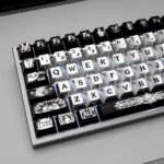 Prometheus PBT keycaps displayed from a unique angle, highlighting their metallic dye-sub finish. The dark, industrial aesthetic embodies mystical angles.