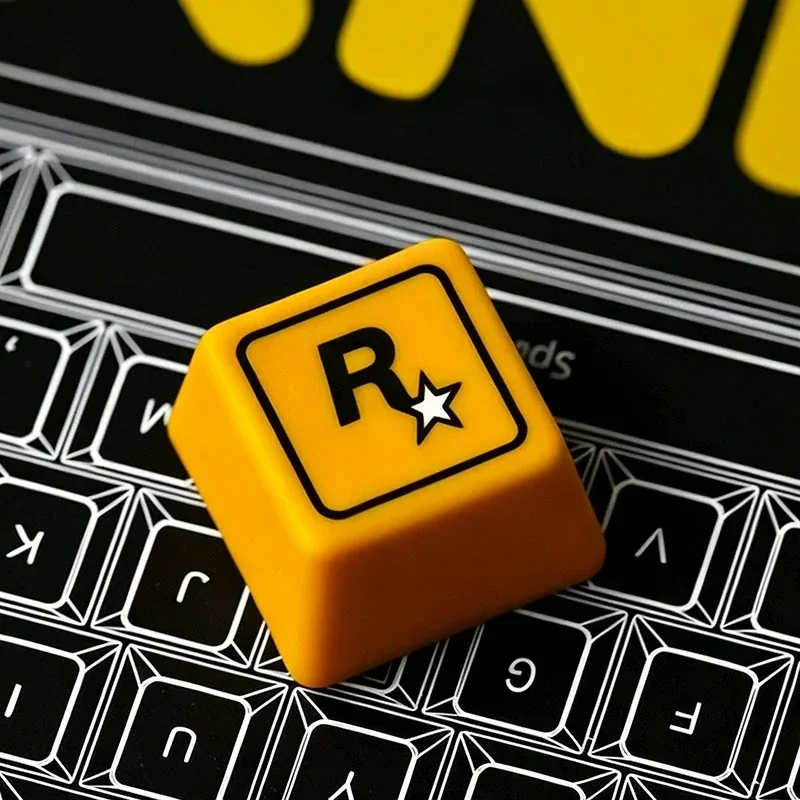 A playful close-up of the iconic Rockstar Games resin ESC keycap, highlighting its bold R* logo and sleek, custom gaming aesthetic from an engaging design.
