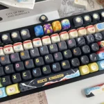A vibrant, character-driven Roco Kingdom MOA PBT keycaps set, showcasing its exclusive dye-sub designs from multiple angles.
