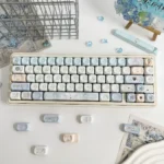Sacred Feather Prayer MOA Keycap Set, an Ethereal MOA Dye-Sub Set, showcasing delicate feather motifs and soft celestial tones for a serene, artistic keyboard.