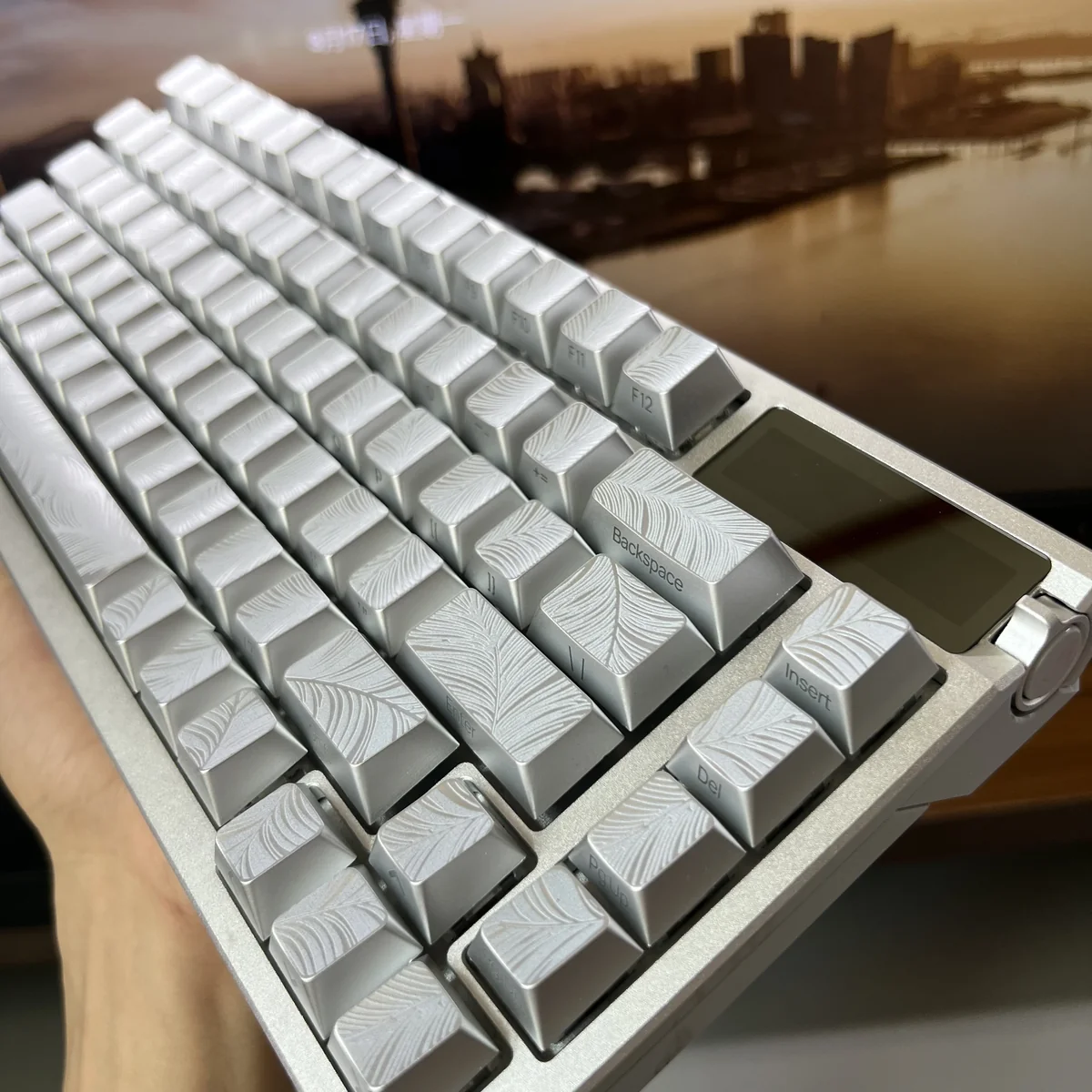 Angled view of ethereal silver keycaps, showcasing the luminous side-engraved characters and their sleek metallic finish.