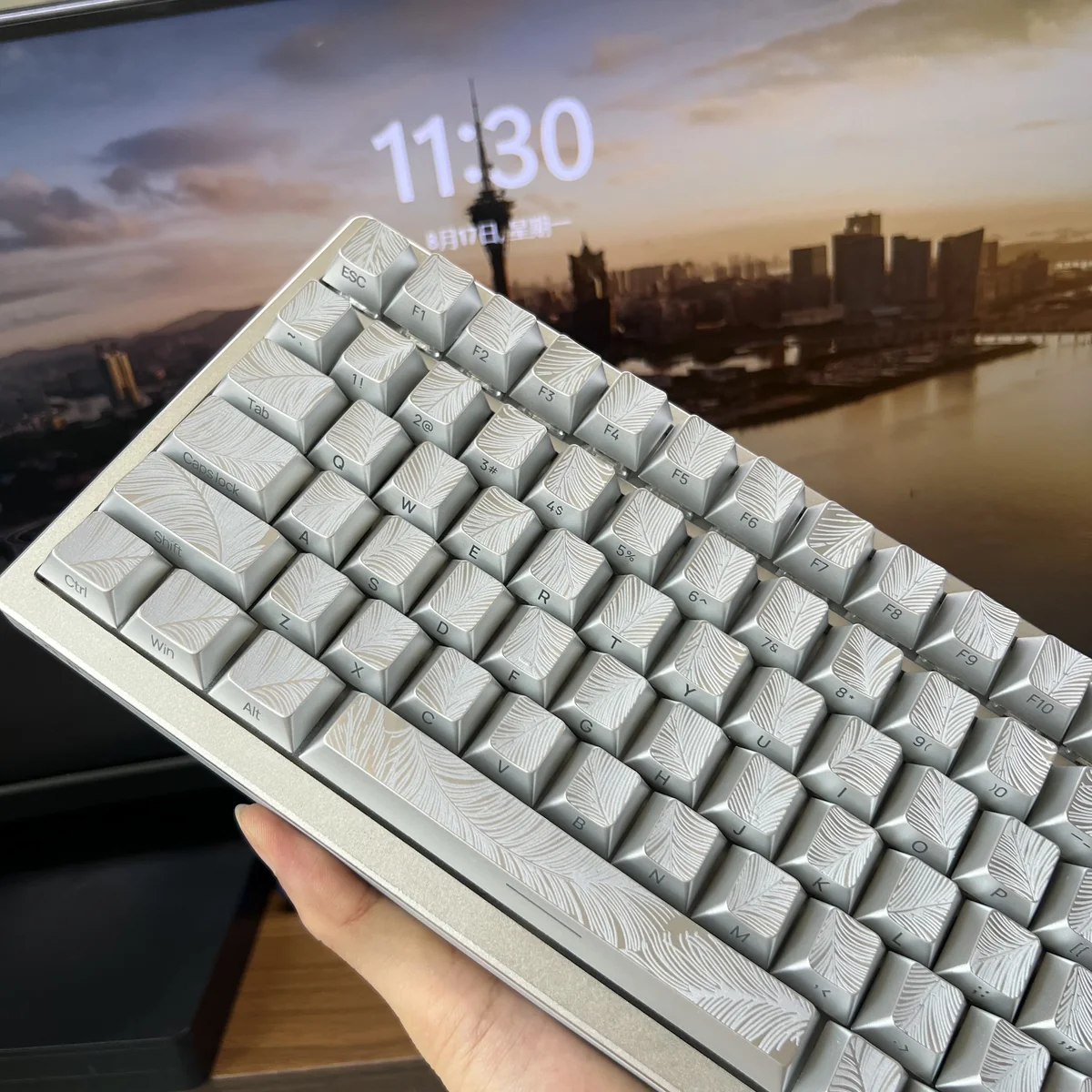 A collection of ethereal silver Feather keycaps, revealing their luminous side-engraved details and sleek metallic design.