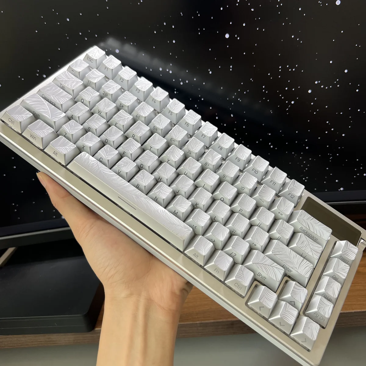 An elegant side view of the silver Feather keycaps, revealing their luminous side-engraved details and the sophisticated metallic sheen.