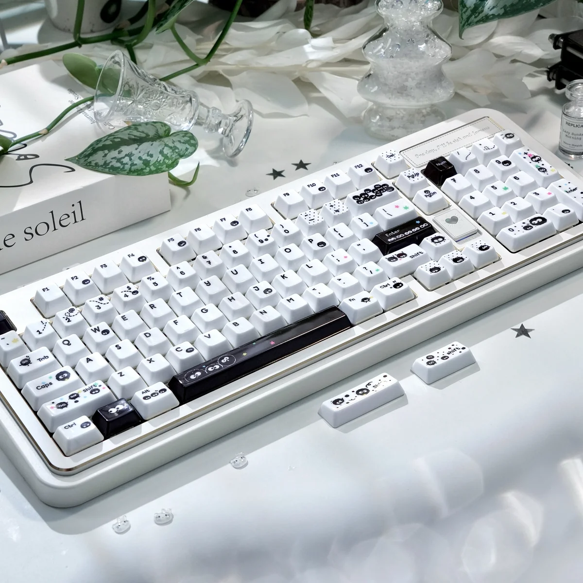 Close-up of a handcrafted Ghibli Susuwatari keycap, showing its whimsical black and white design and unique artisan texture from multiple angles.