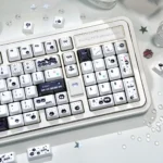 Close-up of a handcrafted Susuwatari keycap, revealing its whimsical Ghibli design and unique black and white texture from an artistic.