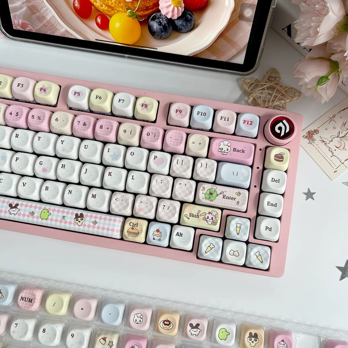 Vibrant MOA profile Tamagotchi PBT keycap set displayed from an overhead perspective, highlighting their playful pixel art and nostalgic retro-tech aesthetics.