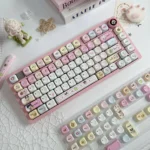 Nostalgic Tamagotchi PBT dye-sub keycaps set, vibrantly displaying playful pixelated characters with a retro-tech aesthetic in MOA profile.
