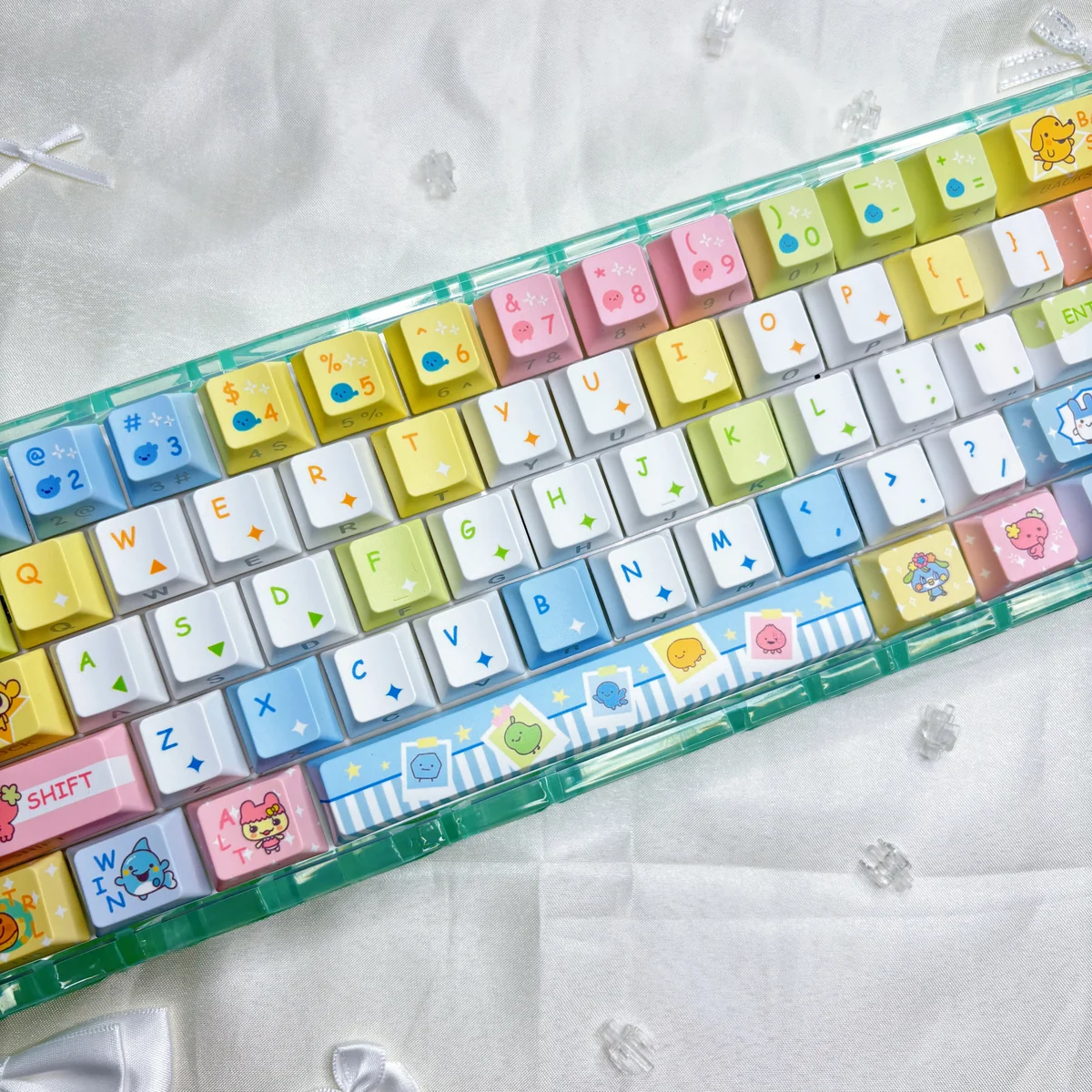 Tamagotchi PBT keycaps set from various angles. Vibrant, pixelated retro digital pet designs provide an exclusive, nostalgic, playful keyboard aesthetic.