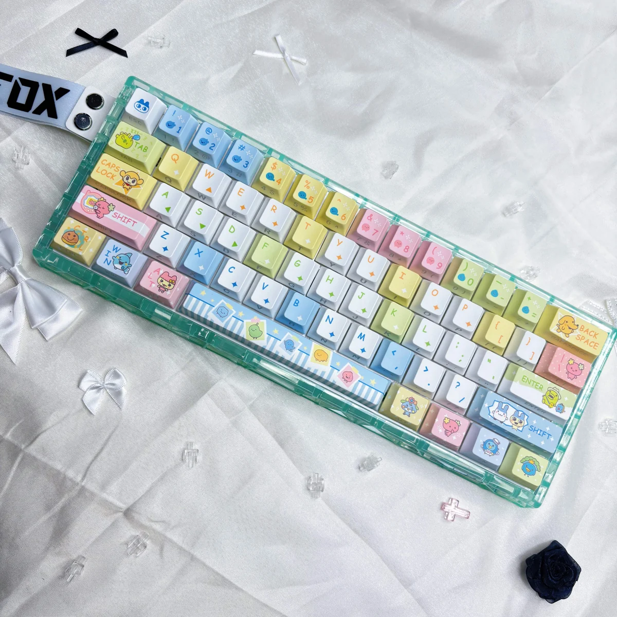 Vibrant Tamagotchi PBT keycaps shown from multiple angles, revealing their exclusive pixelated retro digital pet designs for a playful, nostalgic keyboard.