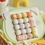 Close-up of the exclusive Yumeiro Patissiere PBT keycap set, showcasing playful anime characters and pastel dessert designs from a unique angle.