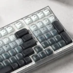 A close-up view of an Ash Island custom keycap set, revealing its serene misty landscape design and muted cool tones. This artistic, premium keycap adds artistic touch.