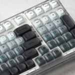 Ash Island Keycap Set: Serene, artistic custom keycap set showcasing a unique misty island design. Premium, minimalist aesthetic, muted cool tones.