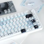 Close-up of charming cat baker PBT dye-sub keycaps, showcasing intricate pastel culinary details and a whimsical kitchen scene from a unique angle.