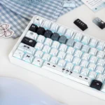 Angled view of the delightful Cat Baker PBT Dye-Sub Keycap Set, showcasing whimsical feline bakers and charming pastel kitchen details.