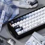 Whimsical Cat Baker PBT Dye-Sub keycap set, 145 keys in a charming box, showcasing playful feline chefs and pastel kitchen scene.