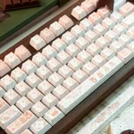 Detailed view of the Charming Cat & Spring Dye-sub PBT Keycap Set, showcasing whimsical cats amidst blossoming pastel flowers.