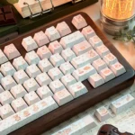 Close-up of the Charming Cat & Spring Dye-sub PBT Keycap Set, showcasing whimsical cats and pastel spring flowers on various keys from different angles.