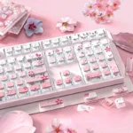 Close-up of a luminous gradient pink cherry blossom PBT keycap set, highlighting crystal-like translucent backlighting and delicate floral details.