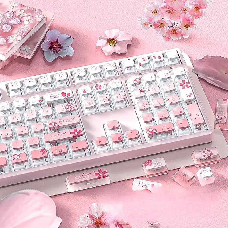 Close-up of a luminous gradient pink cherry blossom PBT keycap set, highlighting crystal-like translucent backlighting and delicate floral details.