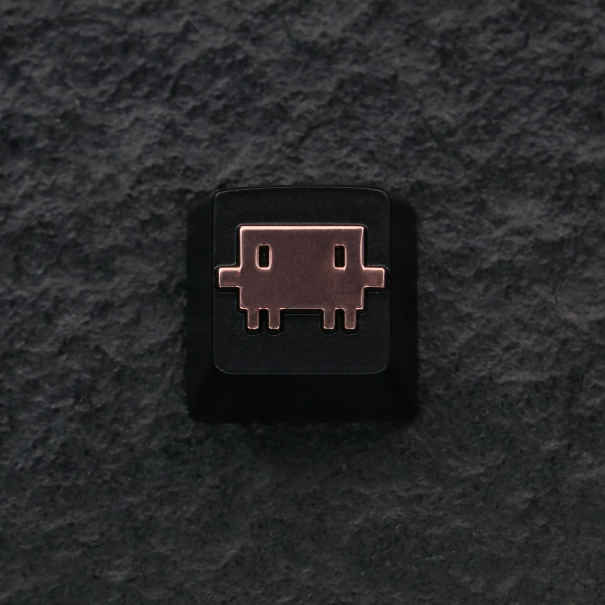 Detailed zinc alloy Claude AI & Mascot Clawd keycap with metallic finish, shown from a unique angle. A premium Claude AI keycap.