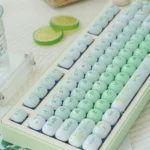 A playful gallery image of the Sweet Nostalgia Dessert Keycap Set, highlighting its glossy PC finish and lush gradient green. The rounded, dessert-inspired.