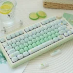 A playful Sweet Nostalgia Dessert Keycap Set, showcasing a glossy PC gradient finish in lush green hues, with rounded, jelly-like keycaps.