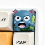 A vibrant, handcrafted Fairy Tail Happy resin keycap, showcasing its intricate 3D design and playful details from a unique side angle.