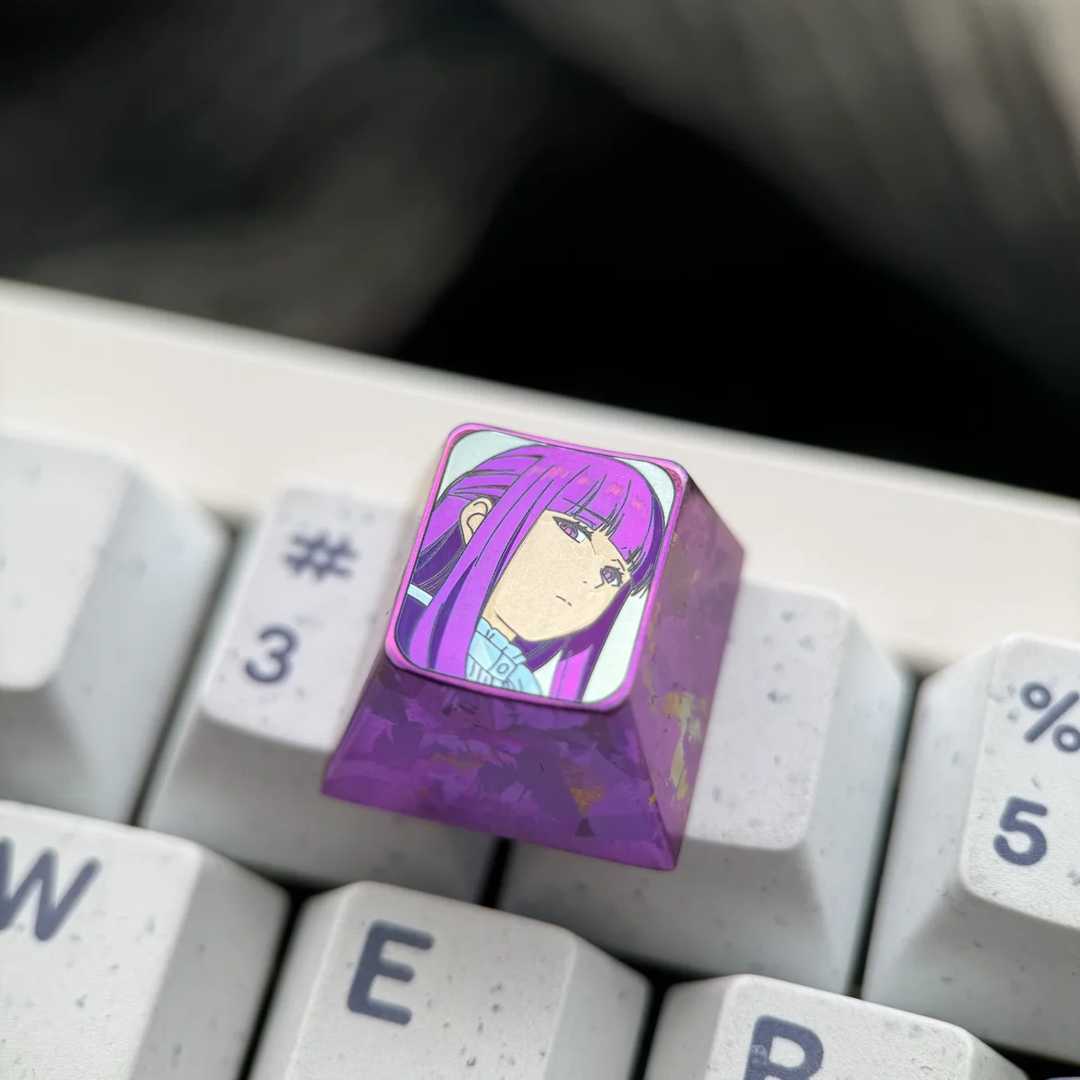 A gallery of views of the premium Fern titanium artisan keycap, showcasing vibrant character art on polished metal, a magical collectible.