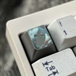Close-up of the Frieren Hand-Carved Titanium Artisan Keycap, revealing Frieren's silhouette on colored matte titanium.