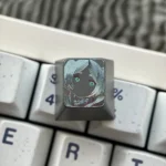 Artistic close-up of the hand-carved Frieren titanium artisan keycap, revealing Frieren's intricate silhouette and delicate lines on its colored matte surface.