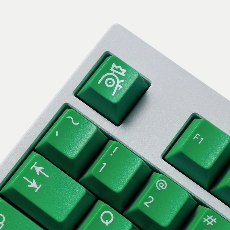 A playful Mischief Keycaps set in vibrant green, showcasing various angles of the durable double-shot ABS keycaps with quirky custom legends.