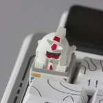 A unique, abstract backlit RX-78-2 Gundam artisan keycap, showcasing a playful monkey-like interpretation for custom mechanical keyboards.
