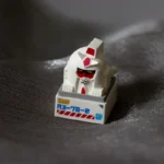 Multiple angles of the unique Abstract Backlit RX-78-2 Gundam Artisan Keycap, revealing its intricate craftsmanship, vibrant glow, and artistic 'monkey' style.