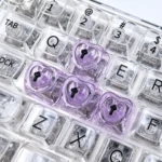 A collection of vibrant, luminous heart keycaps for mechanical keyboards, showcasing their polished, translucent design from multiple artistic angles.