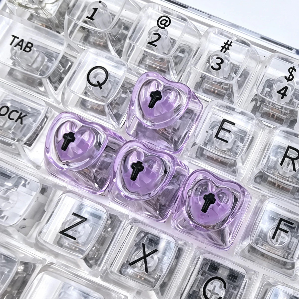 A collection of vibrant, luminous heart keycaps for mechanical keyboards, showcasing their polished, translucent design from multiple artistic angles.