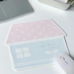 Whimsical Korean house mouse pad from an angled view, highlighting its charming pastel art and anti-slip grip for a playful, stable desk.