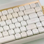 A delightful gallery of Lemon Cream Low Shaft PBT dye-sub keycaps in soft pastel yellow and creamy hues, playfully displayed from multiple angles.