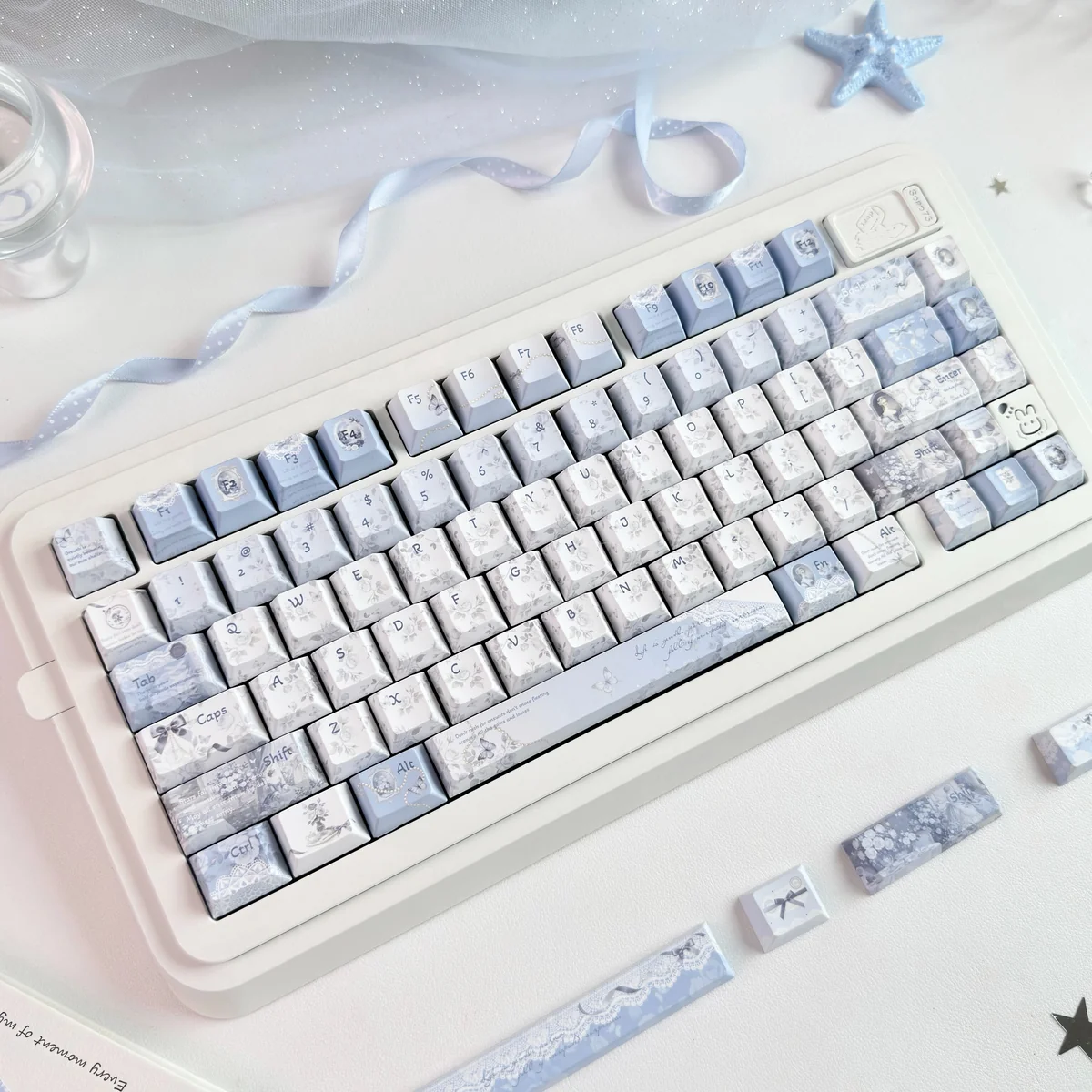 Mist Blue floral PBT dye-sub keycaps, with white patterns on mist blue, displayed from various angles, highlighting tranquil artistic design.