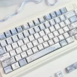 Elegant Mist Blue Floral PBT Dye-sub keycaps showcasing intricate patterns from various angles, highlighting their tranquil artistry and premium quality.