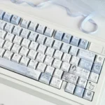 Close-up view of Elegant Mist Blue Floral PBT Dye-sub Keycaps, featuring delicate white floral patterns on soft mist blue, highlighting their tranquil aesthetic.