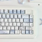 Elegant Mist Blue Floral PBT dye-sub keycap set displayed from multiple artistic angles, highlighting its delicate patterns and tranquil aesthetic.