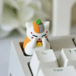 A charming close-up of the exclusive Madara artisan keycap, showcasing its playful, vibrant anime details.